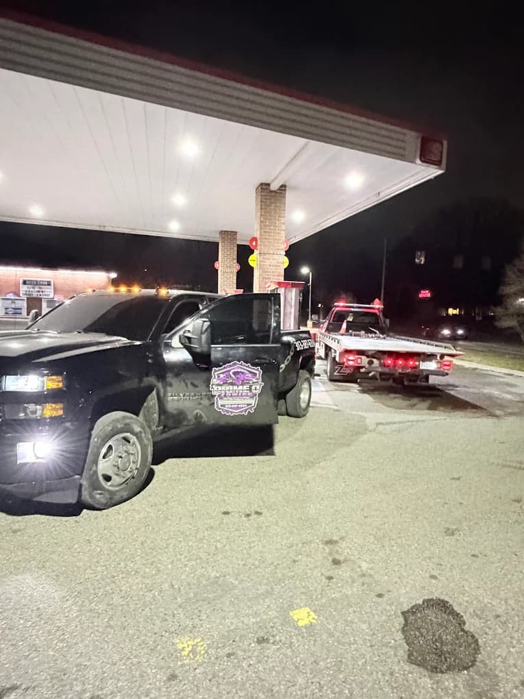 Prime O Towing black dually and flatbed staged together at a Metro Detroit gas station overnight