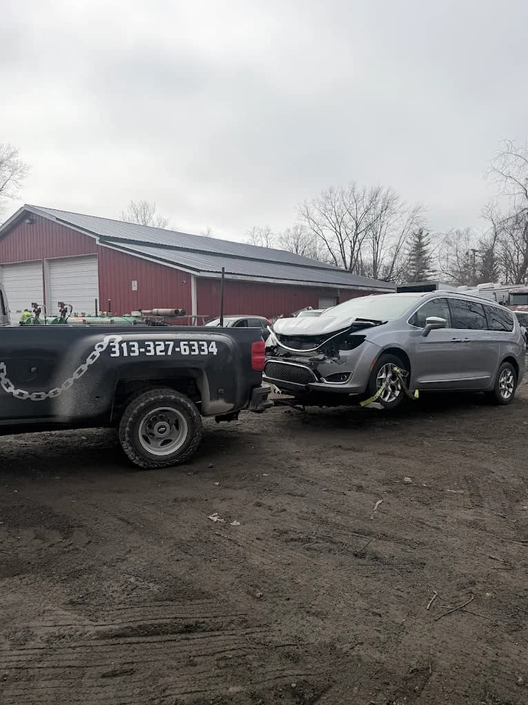 Prime O Towing wheel-lift Silverado recovering a damaged silver SUV from a Metro Detroit auto body shop
