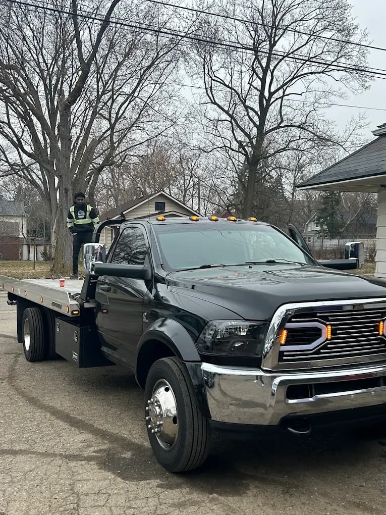 Prime O Towing black Ram 5500 flatbed tow truck on a Metro Detroit street during daytime service